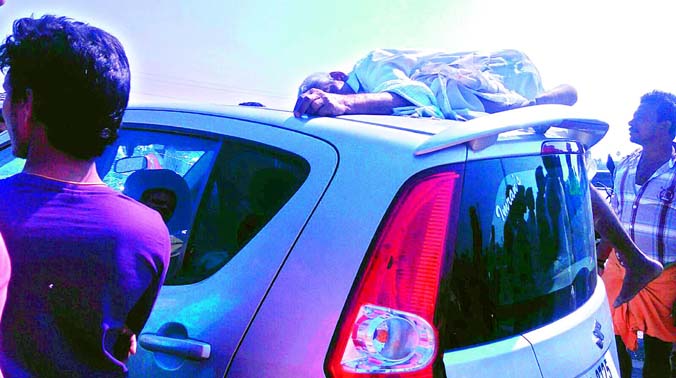 Body of Komirelly Anant Reddy lies on top of the car that hit him while he was crossing the road at Choutuppal on Saturday. (Photo: DC) Body of Komirelly Anant Reddy lies on top of the car that hit him while he was crossing the road at Choutuppal on Saturday. (Photo: DC)